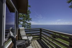 Image of Stunning views of the lake from both inside and out of this beautifully appointed cottage by the lake. This one bedroom cottage has a master bedroom with a king sized bed and a loft area with a queen sized bed. There is also a sleeper sofa in the living area.The cottage offers a full kitchen, is fully furnished, and includes a stone fireplace. 